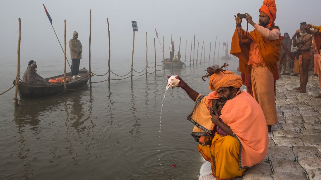 A Sadhu pours water from a conch shell as he prays on the banks of the Ganges river.