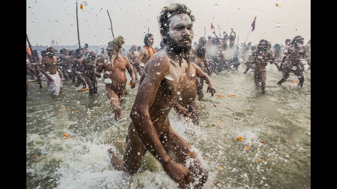 Naga Sadhus run into the waters of the Ganges River during the bathing day of the Maha Kumbh Mela on January 14.