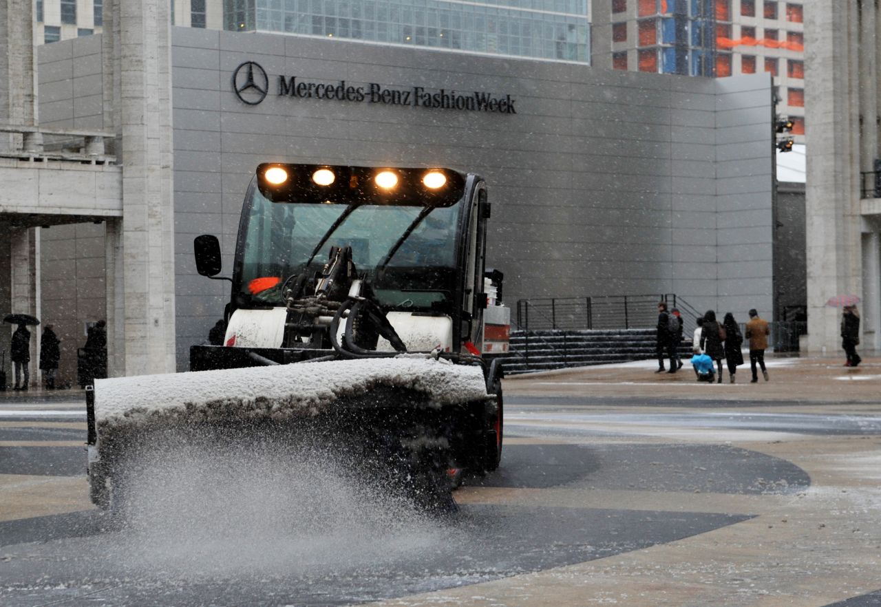 A sweeper clears snow in front of the Mercedes-Benz Fashion Week tents on February 8 at Lincoln Center in New York.