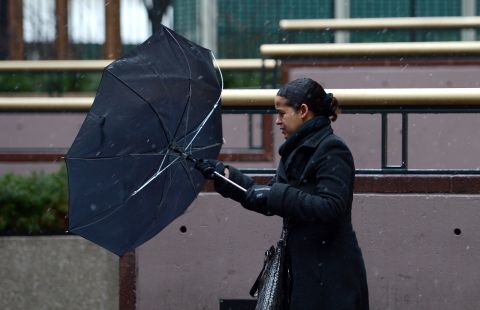 A woman tries to right her umbrella while dealing with wind and precipitation in New York on February 8.