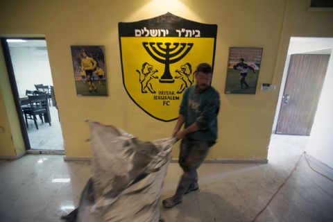 A club official at Beitar Jerusalem cleans up after the arson attack on the club's offices.