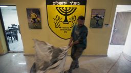 A club official at Beitar Jerusalem cleans up after the arson attack on the club's offices.