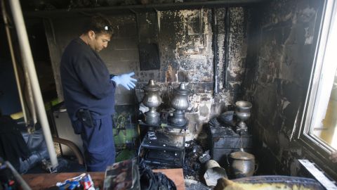 A club official examines the charred remains of the trophies won by Israeli league side Beitar Jerusalem after an arson attack on its clubhouse.   
