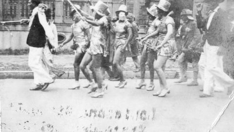 In a photo from the State Library of Louisiana, women wear Baby Doll-style costumes in a 1930s street parade.