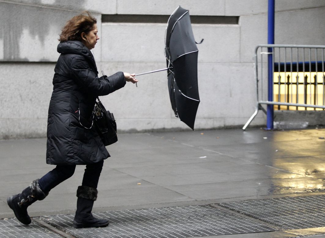 A woman struggles with her umbrella in New York's Financial District on February 8. Accumulations of up to a foot of snow are expected in the Big Apple.