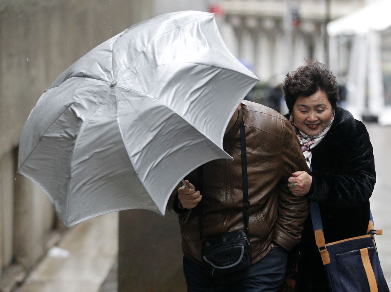 Tourists brave the high winds in New York's Financial District on February 8.