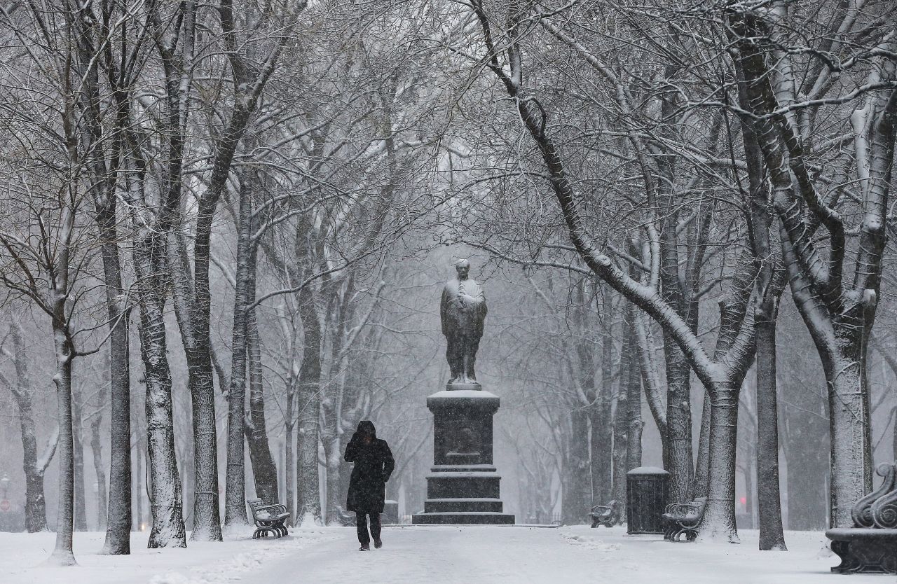 Jeannine Strampel walks through the snow past a statue of Alexander Hamilton along Commonwealth Avenue Mall on February 8.