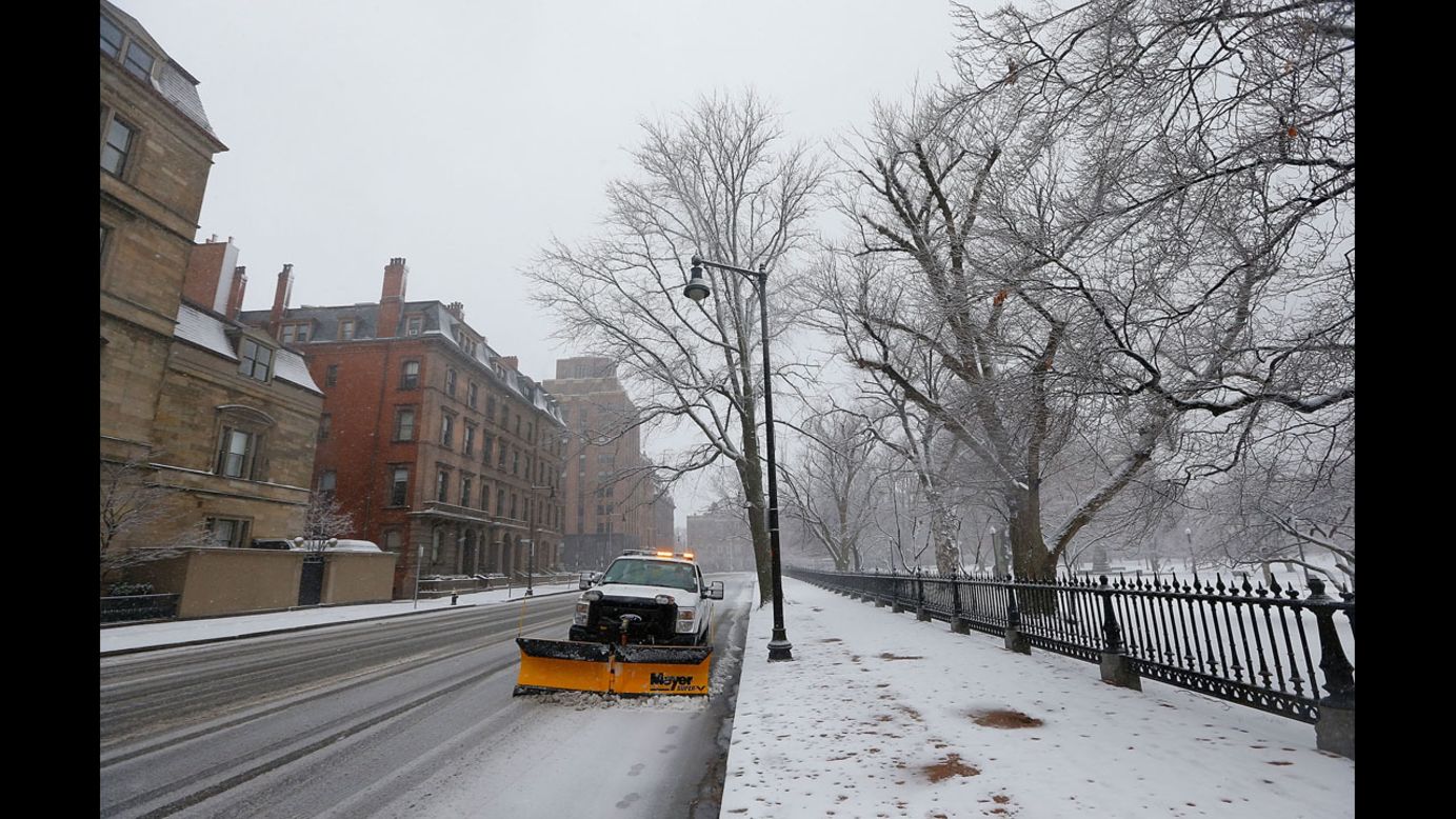 A snowplow sits on the street while snow falls near Boston Common on Friday. 