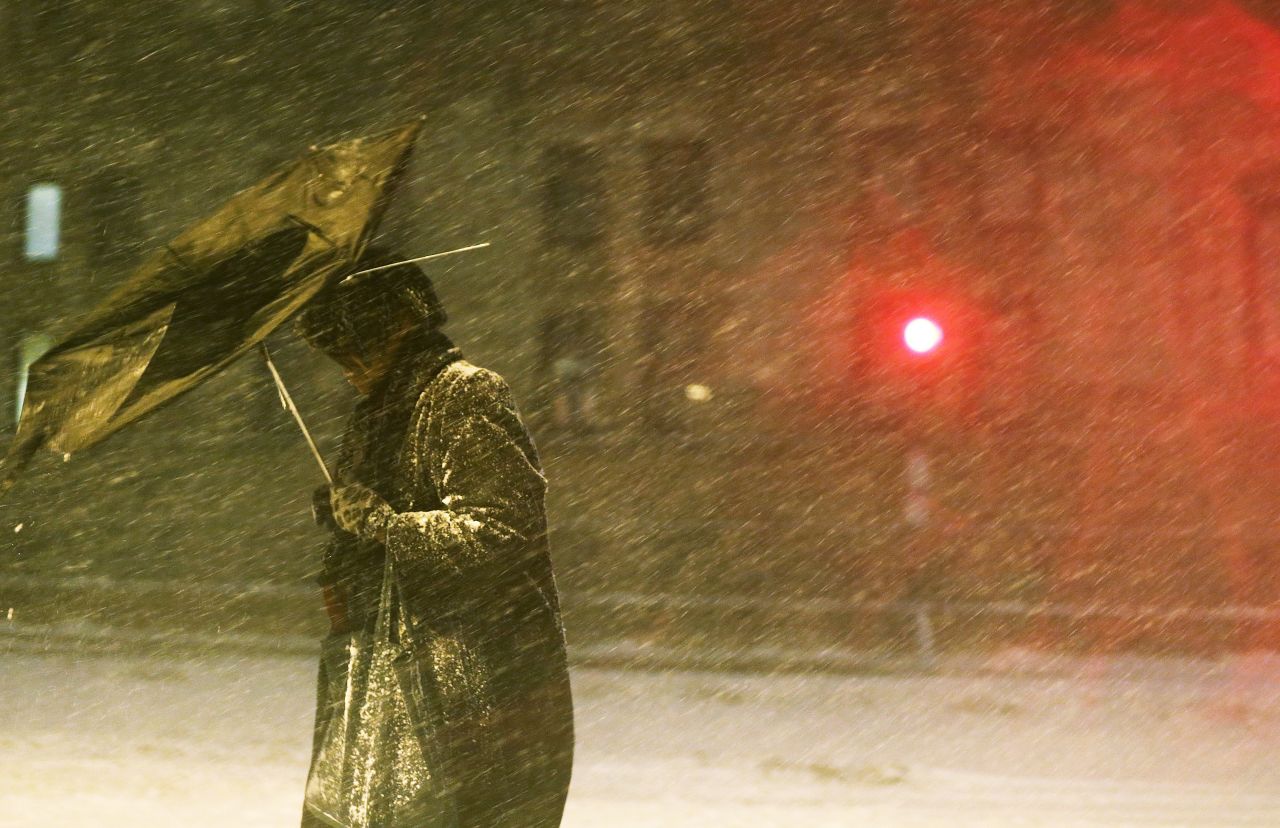 A pedestrian makes his way through driving snow with a broken umbrella in the Back Bay neighborhood on Friday, February 8 in Boston.