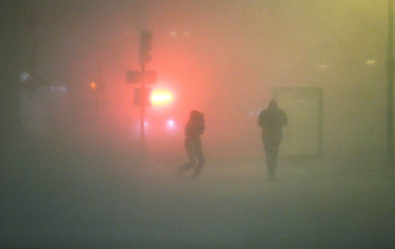 People walk through the blowing snow while a blizzard arrives in the Back Bay neighborhood on February 8 in Boston.