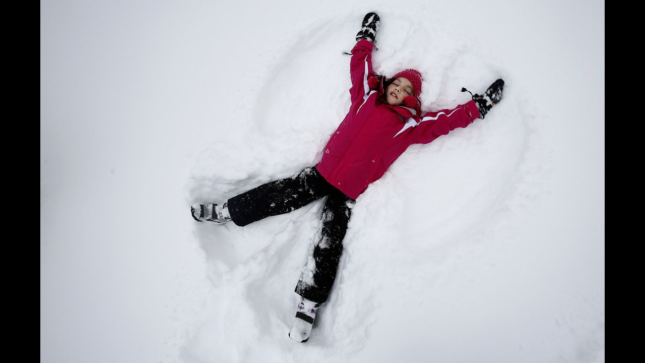 Phoebe Lightburn, 9, makes a snow angel in Central Park in New York.