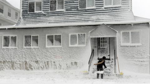 A man shovels snow along Winthrop Shore Drive in Winthrop, Massachusetts.