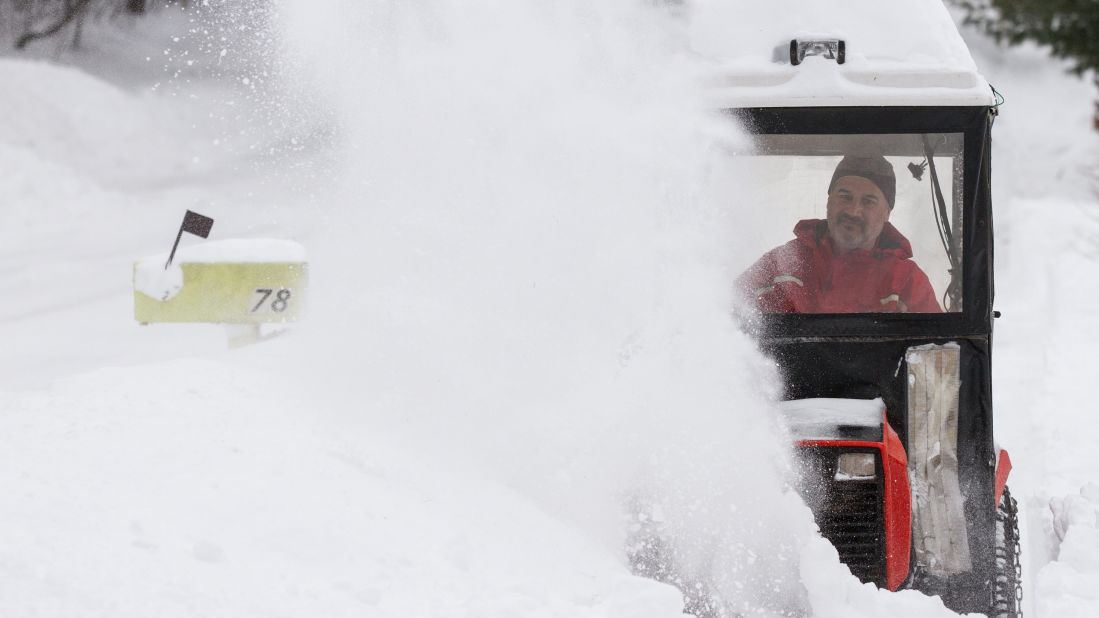 Paul DeCarlo uses a snow blower to clear the walk in front of his house in Greenfield, Massachusetts.