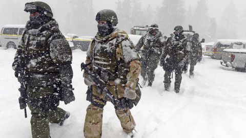 San Bernardino County Sheriff SWAT team members return to the command post at Bear Mountain in Big Bear Lake, California, on Friday, February 8, after heavy snow hindered the manhunt for ex-LAPD cop Christopher Jordan Dorner.