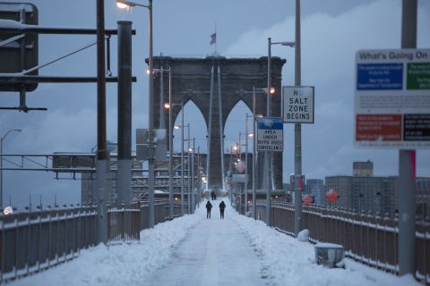 People walk along the Brooklyn Bridge following a major winter storm on Saturday in New York City. Possible record-setting blizzard conditions are expected with heavy snow warnings in effect from New Jersey through southern Maine.