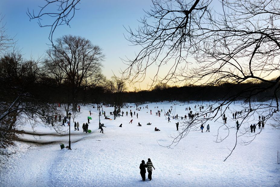 People walk and sled through a snowy Prospect Park in Brooklyn, New York, on Saturday.