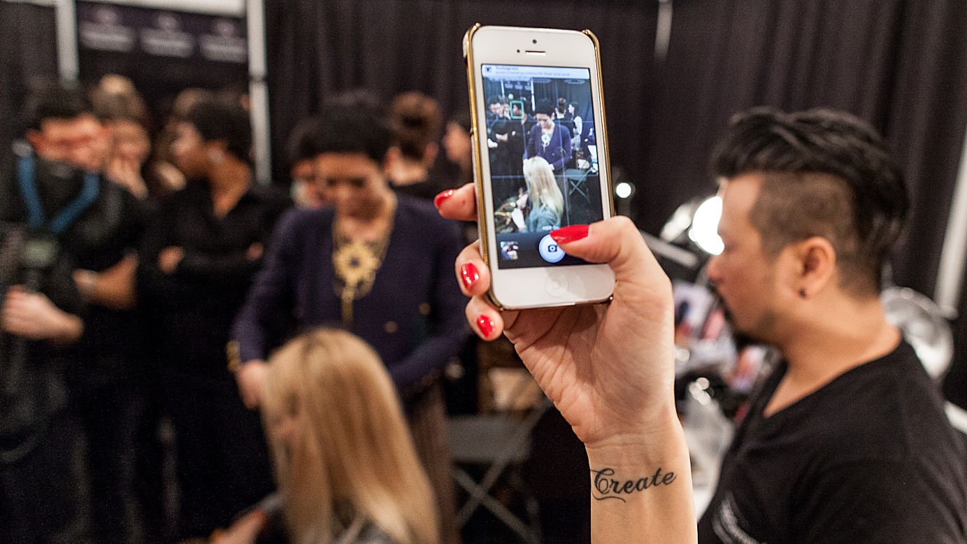A woman takes a photo of teams and models backstage at the Tracy Reese show February 10.
