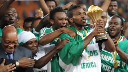 Nigeria's captain Joseph Yobo holds the Africa Cup of Nations trophy, which had been handed to him by South African President Jacob Zuma (L) at Soccer City stadium in Johannesburg.