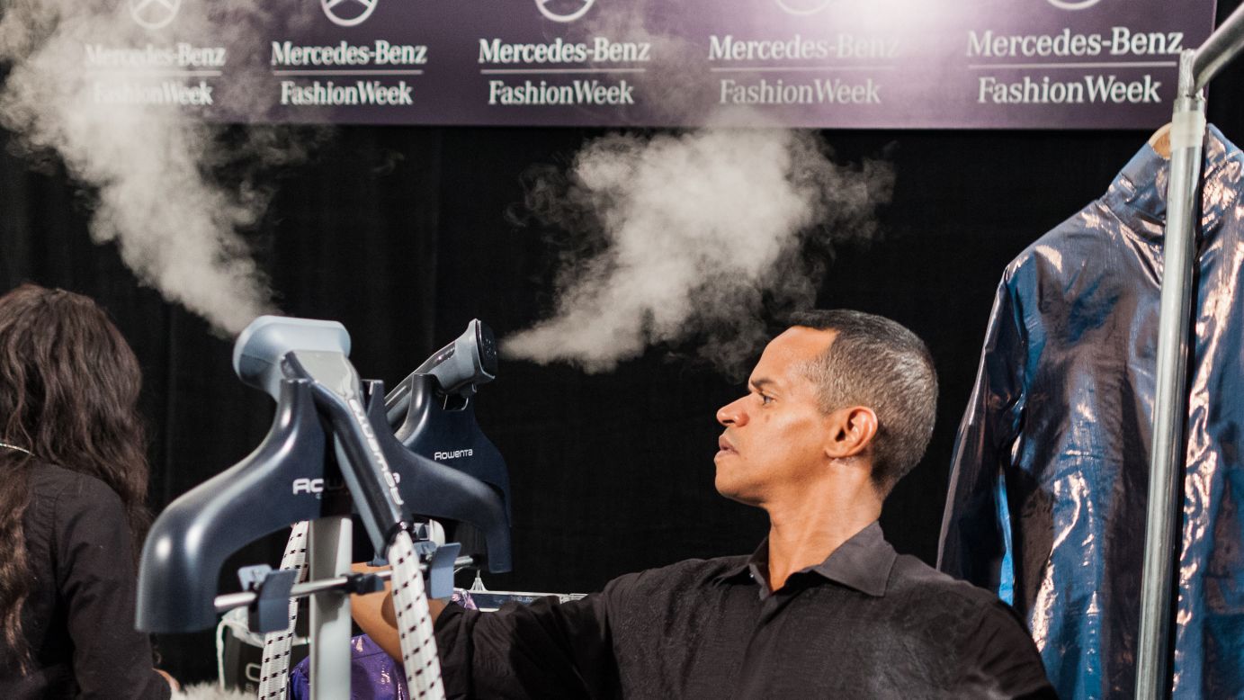 Tailors use steam machines to remove wrinkles from outfits backstage at the Custo Barcelona show on February 10.