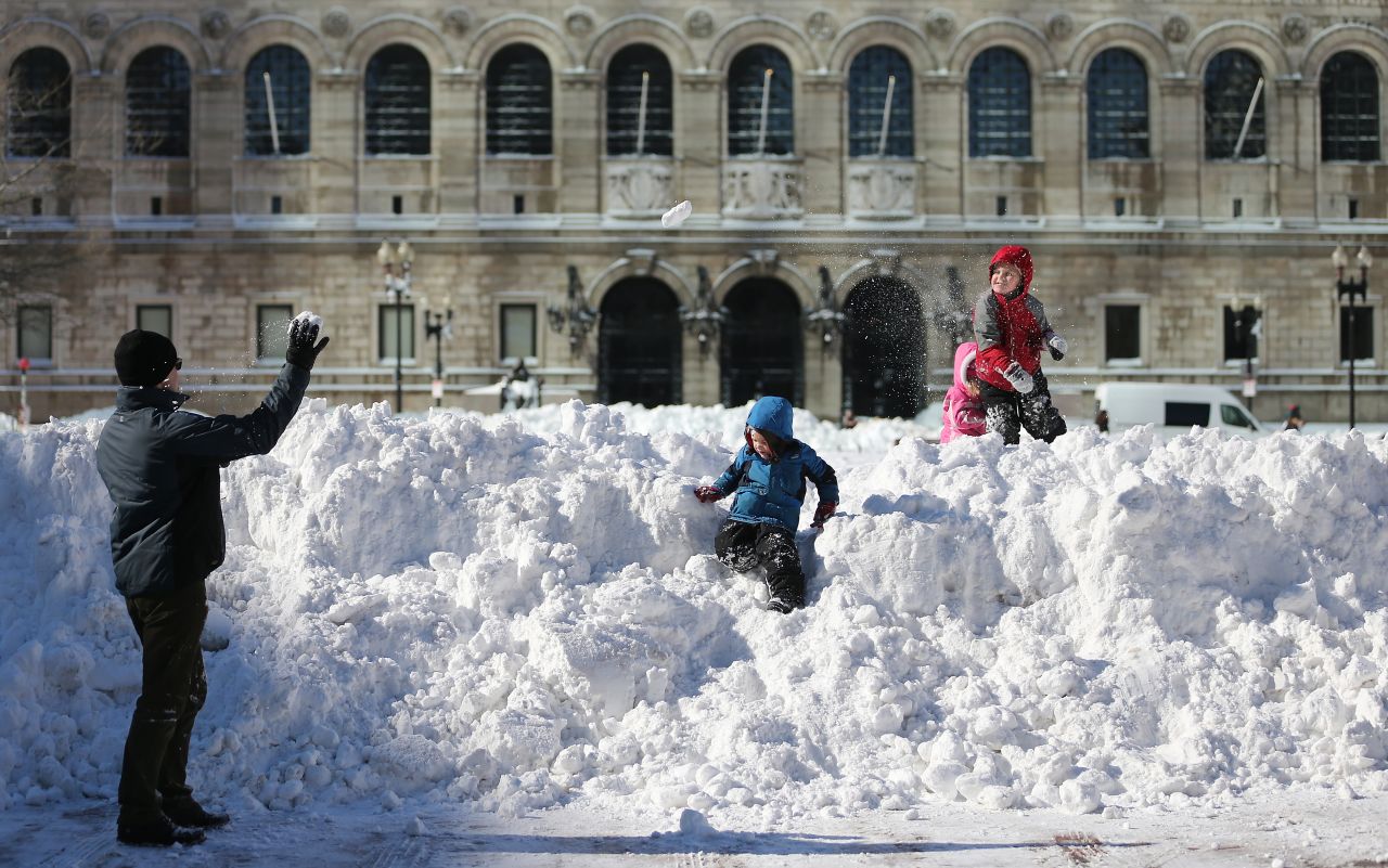 Sean McCullough, left, plays with his children in Copley Square in Boston on Sunday, February 10, following a powerful blizzard. The storm dumped more than two feet of snow in parts of New England.
