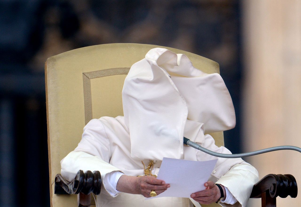 A gust of wind blows Benedict's collar into his face in September 2012 during his weekly address in Saint Peter's Square.