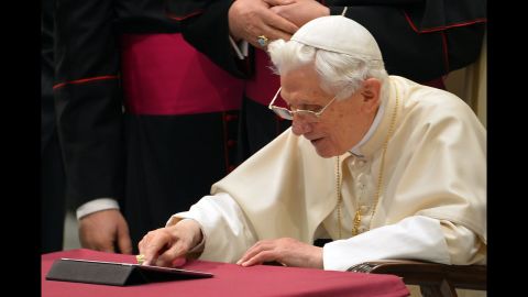 Pope Benedict XVI clicks on a tablet to send his first twitter message at the Paul VI hall at the Vatican, December 12, 2012.