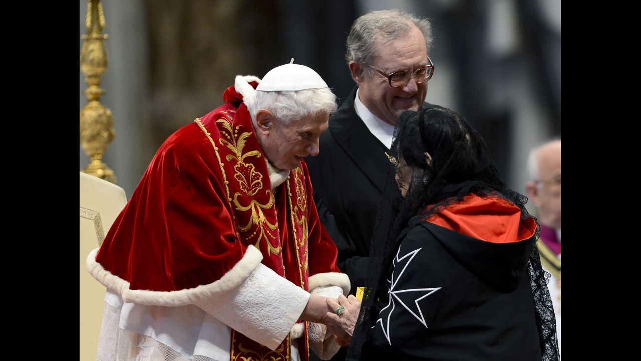 Benedict, accompanied by Grand Master Matthew Festing of the Sovereign Military Order of Malta, right,  shakes hands with a woman after the Mass in St. Peter's Basilica to mark the 900th anniversary of the Order of the Knights of Malta on February 9, 2013, at the Vatican.    