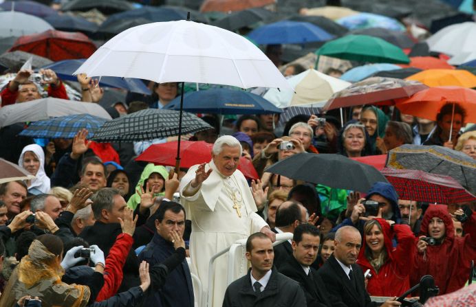 El Papa saluda a la multitud debajo de una sombrilla cuando llegaba para realizar su audiencia general semanal en la Plaza de San Pedro en la Santa Sede, octubre de 2007. 