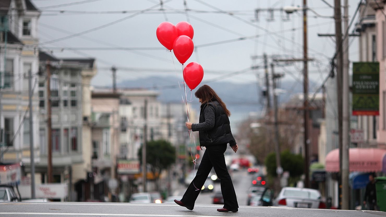 A woman carries a bunch of balloons as she walks down Union Street in San Francisco on Valentine's Day 2011.