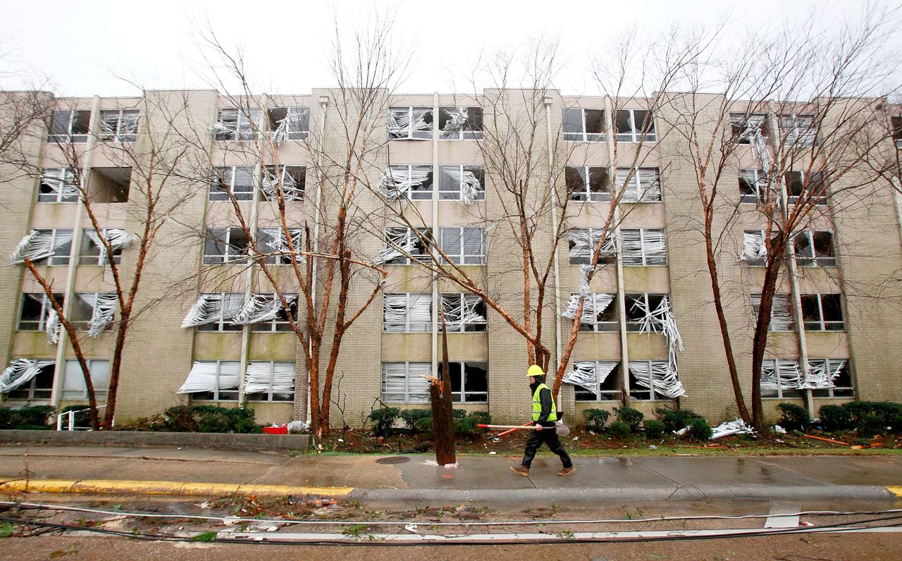 An electrical crew worker walks past a building with blown-out windows across from the University of Southern Mississippi in Hattiesburg on February 11. Dozens of people were injured in the storm in the Mississippi town.