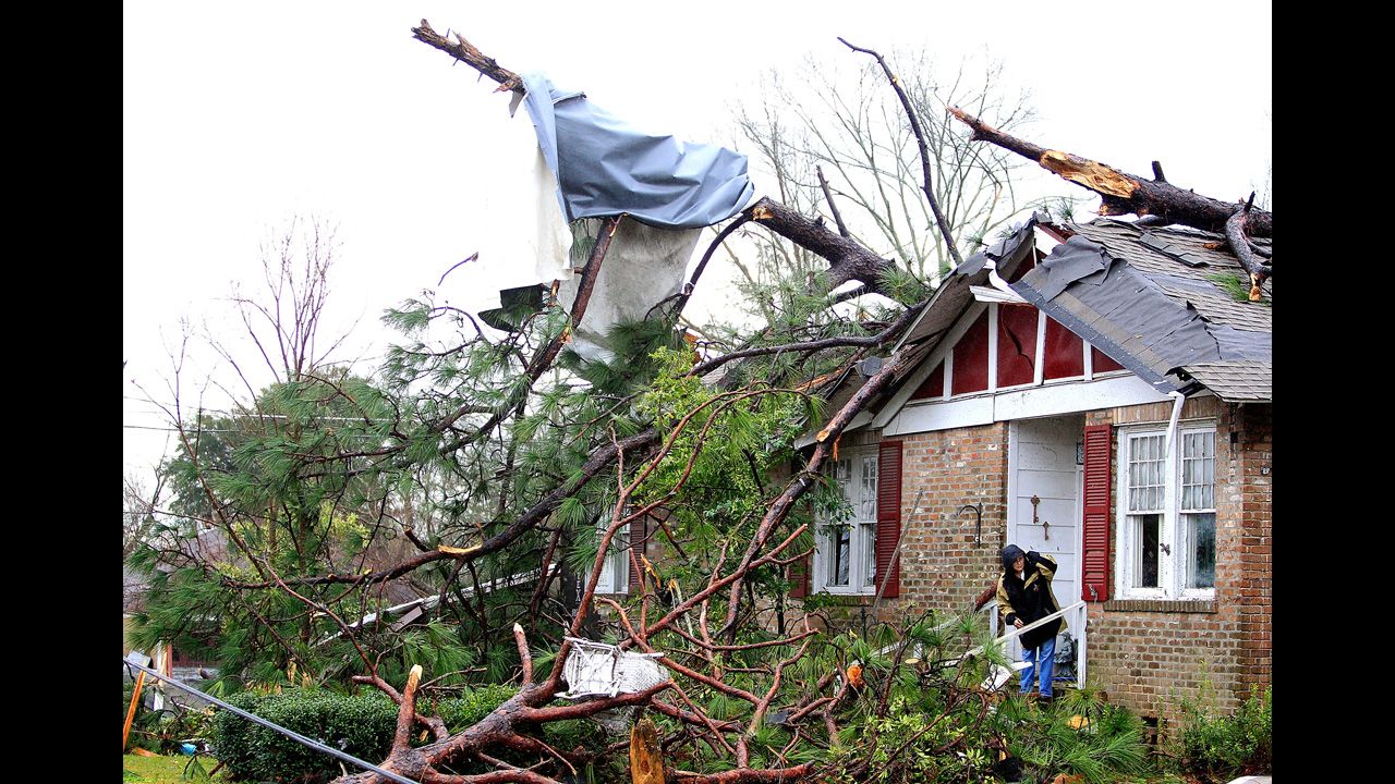 A woman eyes the devastation from her damaged home in Hattiesburg on February 11.
