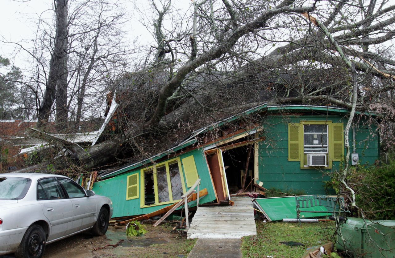 A tree lies atop a house on Monday, February 11, in Hattiesburg, Mississippi, the day after a tornado barreled through the area. At least 15 tornadoes formed across southern Mississippi and Alabama as a cold front moved in Sunday, February 10.
