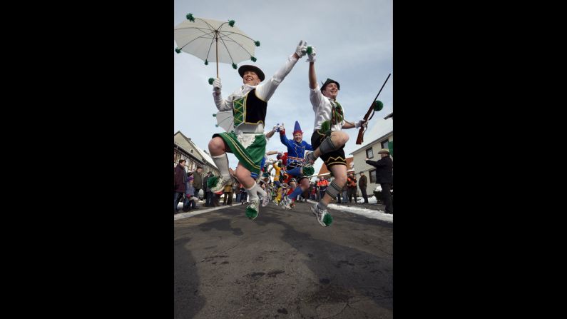 People jump about at the Springerzug carnival parade,.