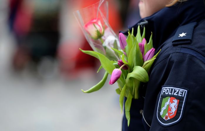 A policewoman in Düsseldorf wears flowers on her jacket.