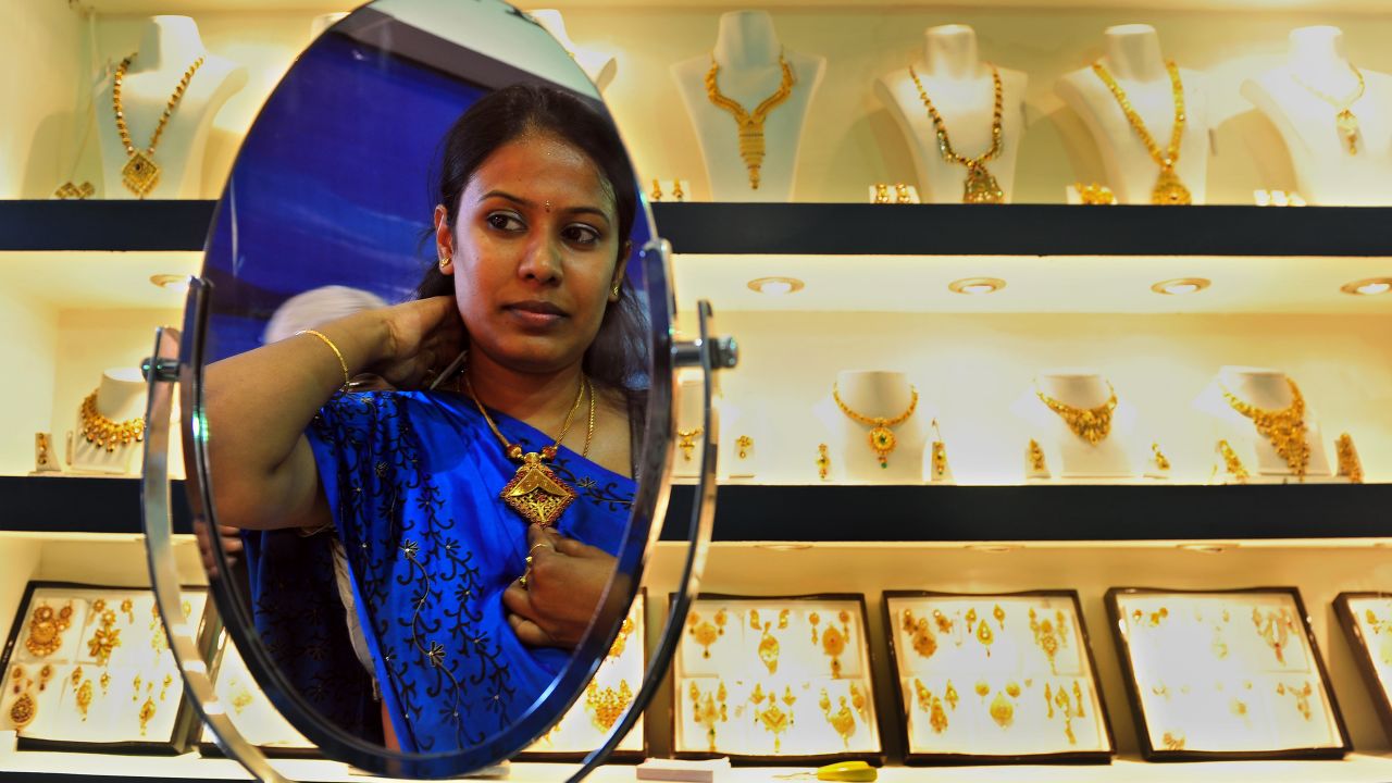 An Indian customer tries on a piece of gold jewellery in Bangalore on October 14, 2011.