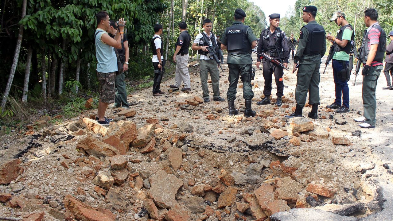 Policemen inspect a bomb site in the southern province of Narathiwat on Sunday, part of a recent wave of separatist violence.