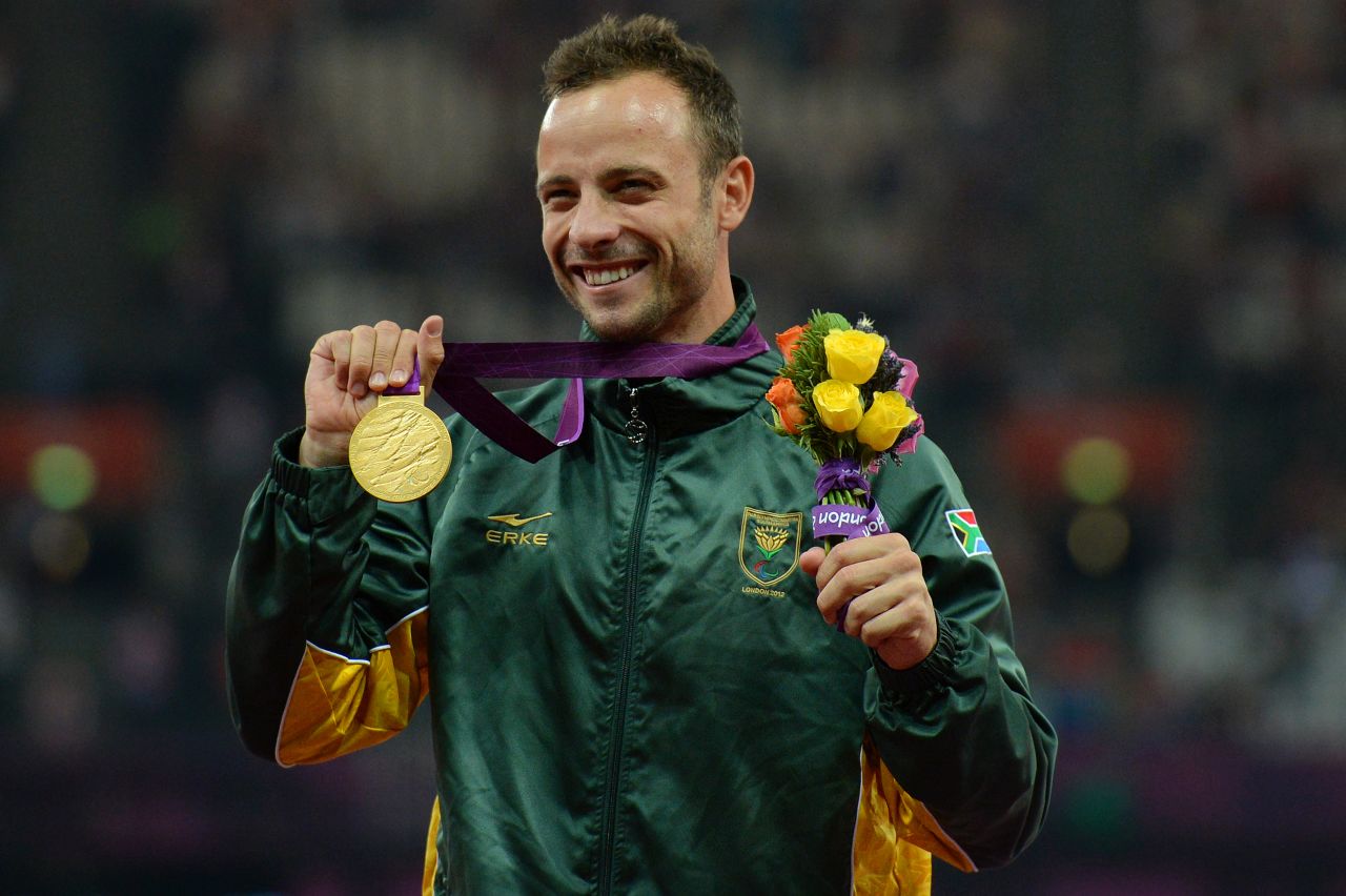 Pistorius poses on the podium with his gold medal after winning the men's 400-meter T44 final at the 2012 Paralympic Games.