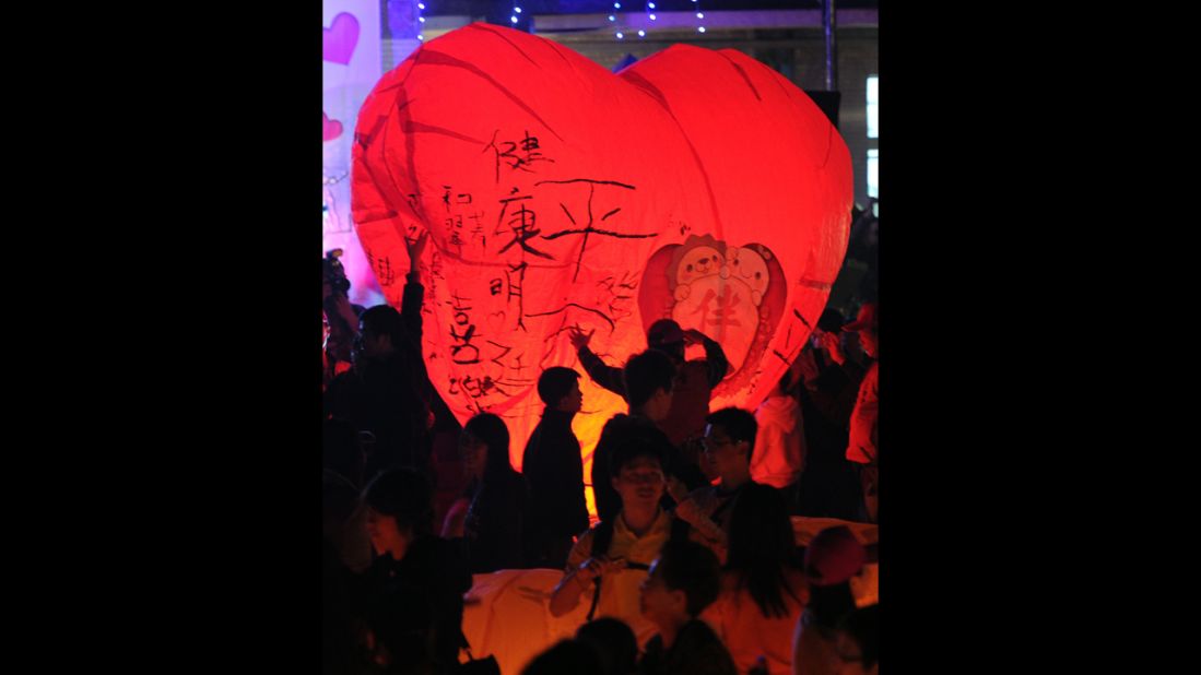 Residents of Taiwan release a heart-shaped sky lantern. 