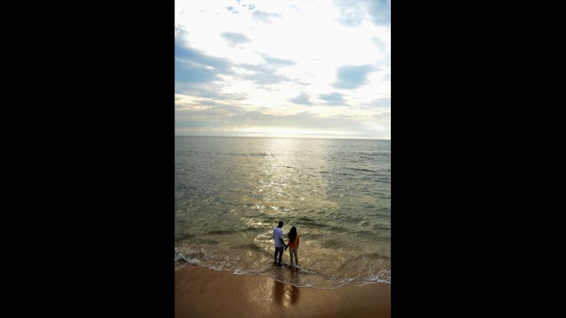 A couple stands on the Galle Face beach in Colombo, Sri Lanka.