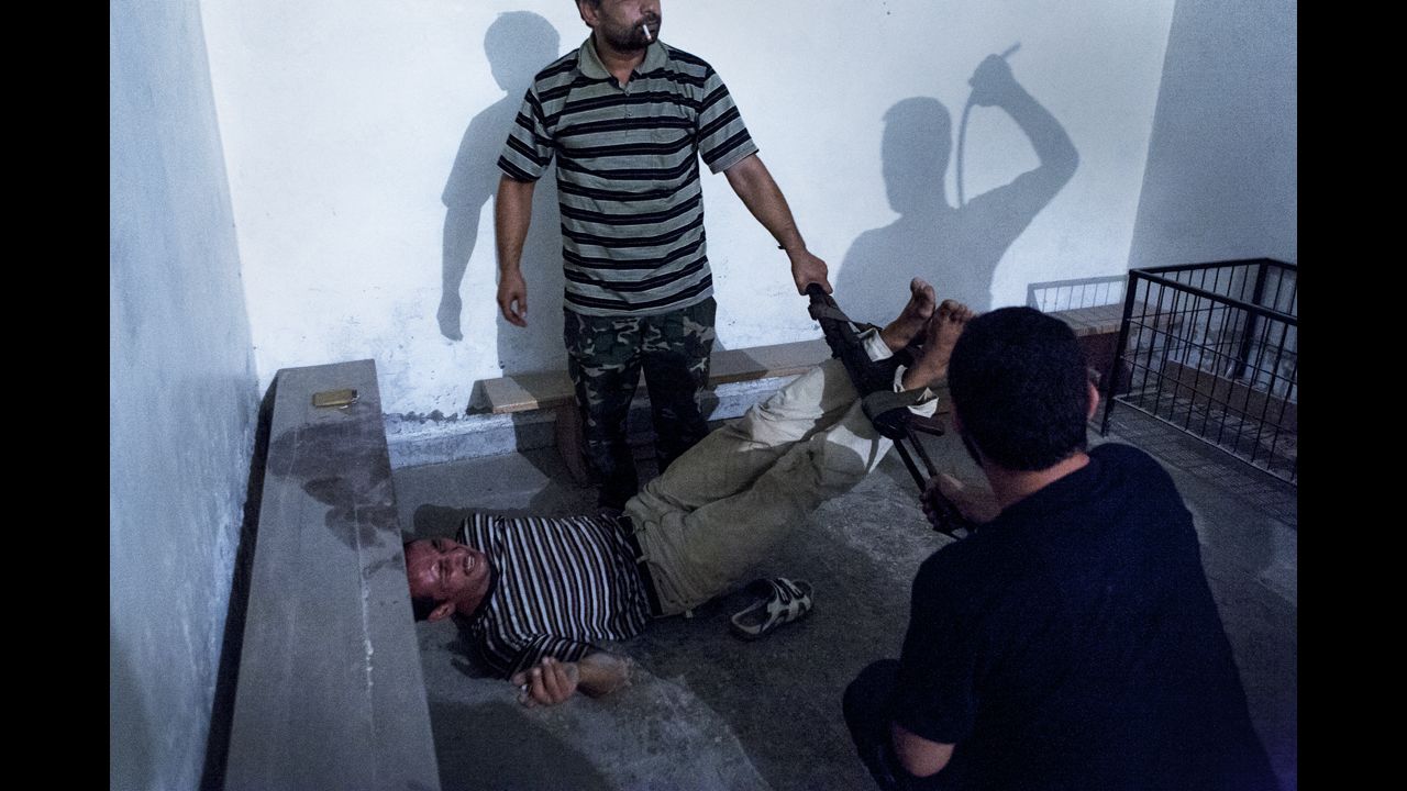 <strong>Second prize -- spot news single:</strong><br />Syrian opposition fighters interrogate captured government informants on July 31, 2012, in Aleppo, Syria, in a photograph by Emin Ozmen. The informants were declared guilty and tortured throughout the night, according to Ozmen.