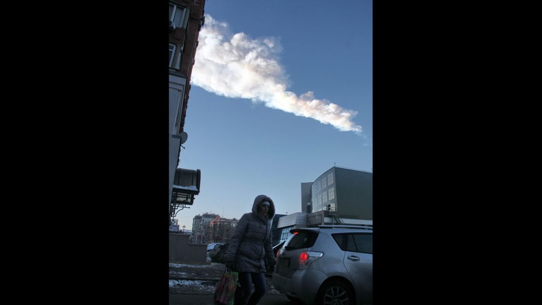 The meteor's vapor trail passes over the city. 