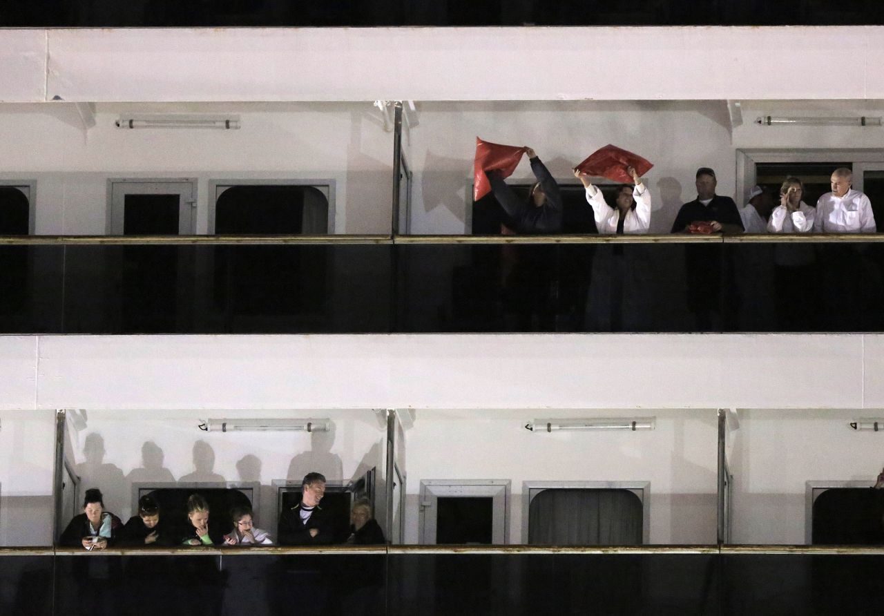Passengers wave from the decks of the Triumph after docking at the Alabama Cruise Terminal in Mobile.