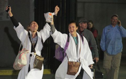 Passengers cheer after stepping off the crippled cruise ship. The last ones got off early Friday, February 15.