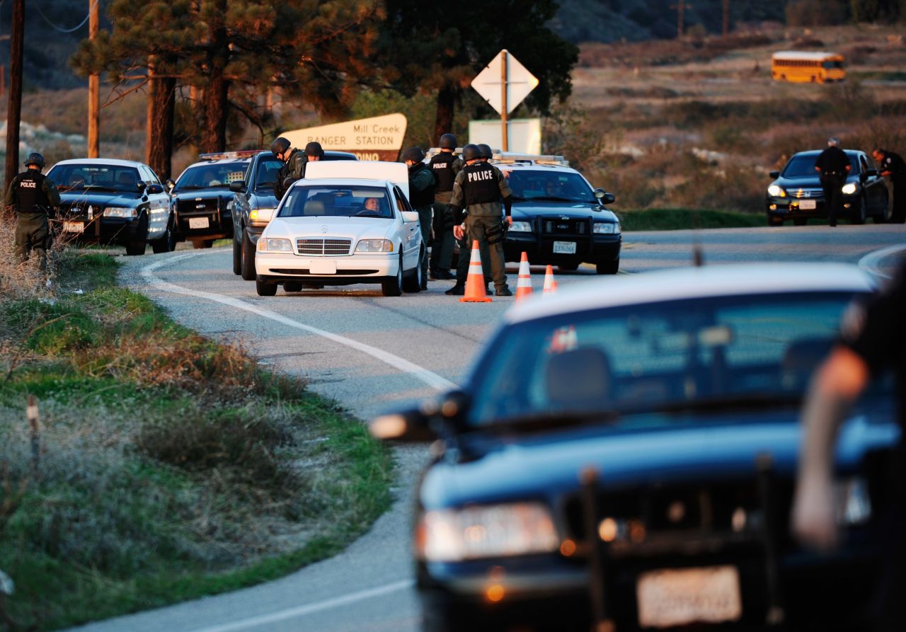 Police search cars at a blockade as they come down off the mountain during a manhunt for Dorner on February 12.