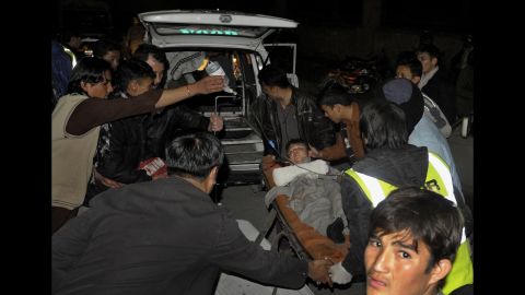 Relatives and medical staff shift an injured bomb blast victim into an emergency vehicle. 