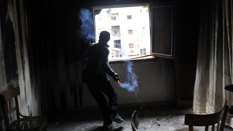 A rebel fighter throws a home-made grenade at Syrian government forces in Aleppo on February 16.