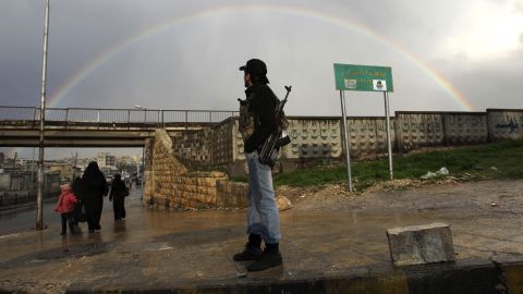 A member of the Free Syrian Army stands with his weapon as he looks at a rainbow in Aleppo on February 16.