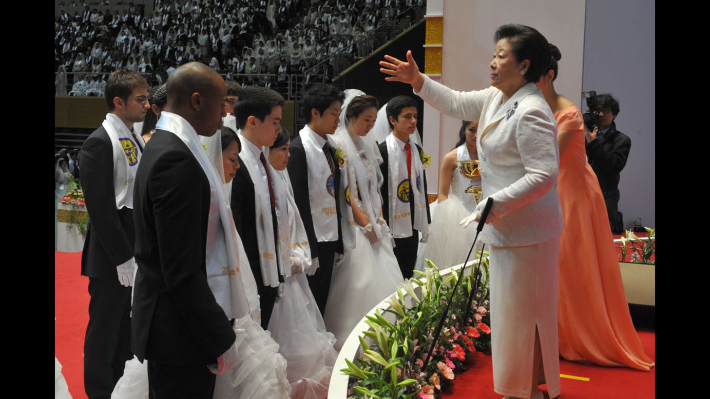 Hak Ja Han Moon, right, the widow of the late Unification Church founder Sun Myung Moon, sprinkles the church's holy water onto newly married couples. This was the first Cosmic Blessing since the death of Sun Myung Moon, who <a href="http://www.cnn.com/2012/09/02/world/asia/south-korea-reverend-moon-dead" target="_blank">passed away in September 2012</a>.