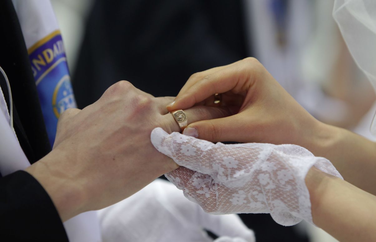 Couples exchange their wedding rings.