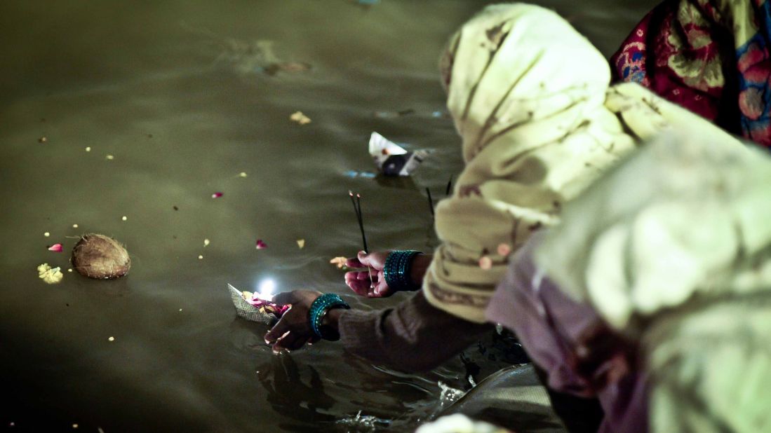 A woman places a floating candle on the Sangam on Sunday, February 17.